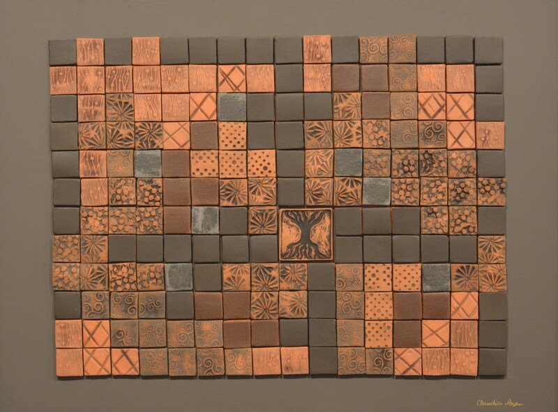 Handmade tile mosaic in terra cotta and black with world tree focal point on grey background